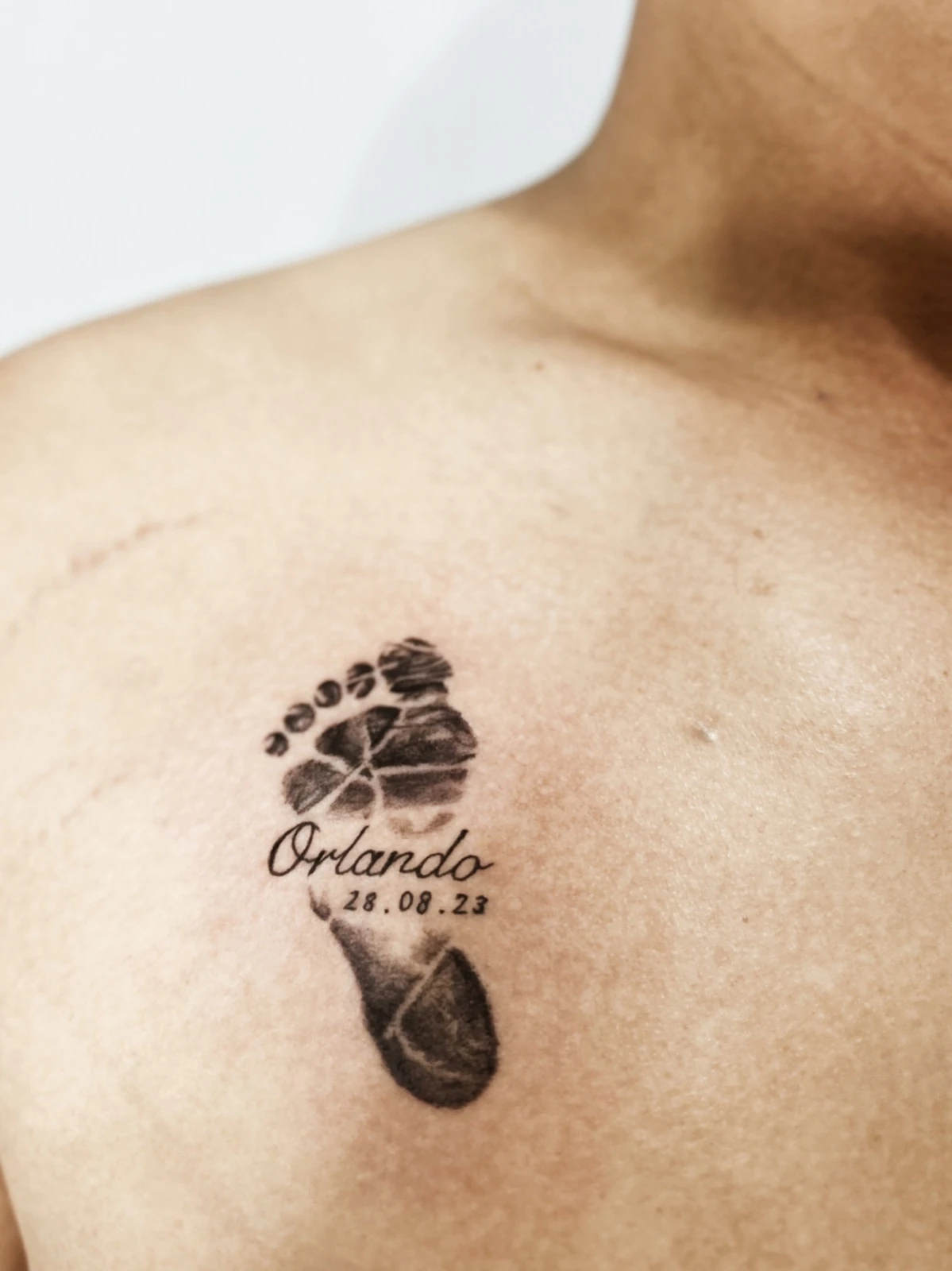 Tattoo jejak kaki dengan tulisan di bahu · Meigu Tattoo