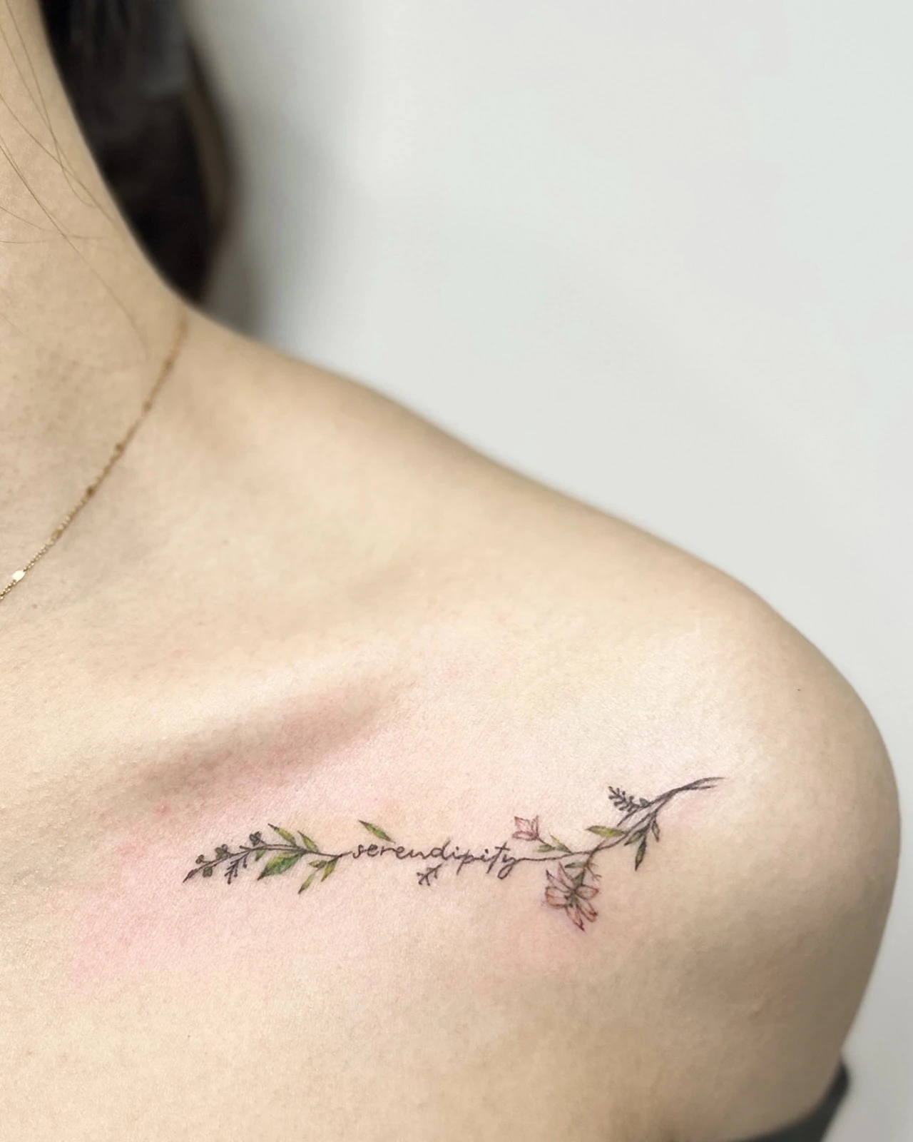 Tattoo rangkaian bunga dan daun di dada atas · Meigu Tattoo