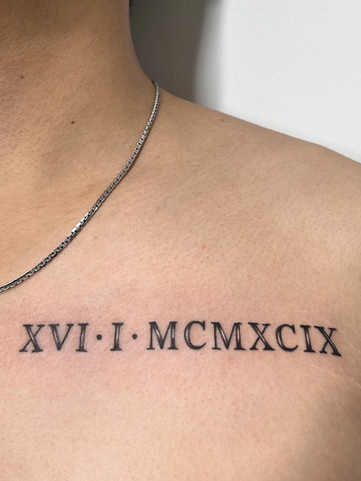 Tattoo angka Romawi di dada atas · Meigu Tattoo