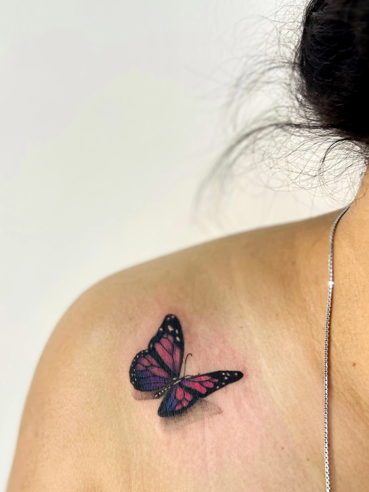 Tattoo kupu-kupu hitam dan merah muda di bahu · Meigu Tattoo