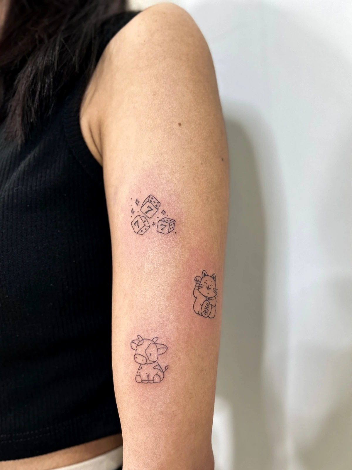 Tattoo beberapa karakter kecil di lengan · Meigu Tattoo