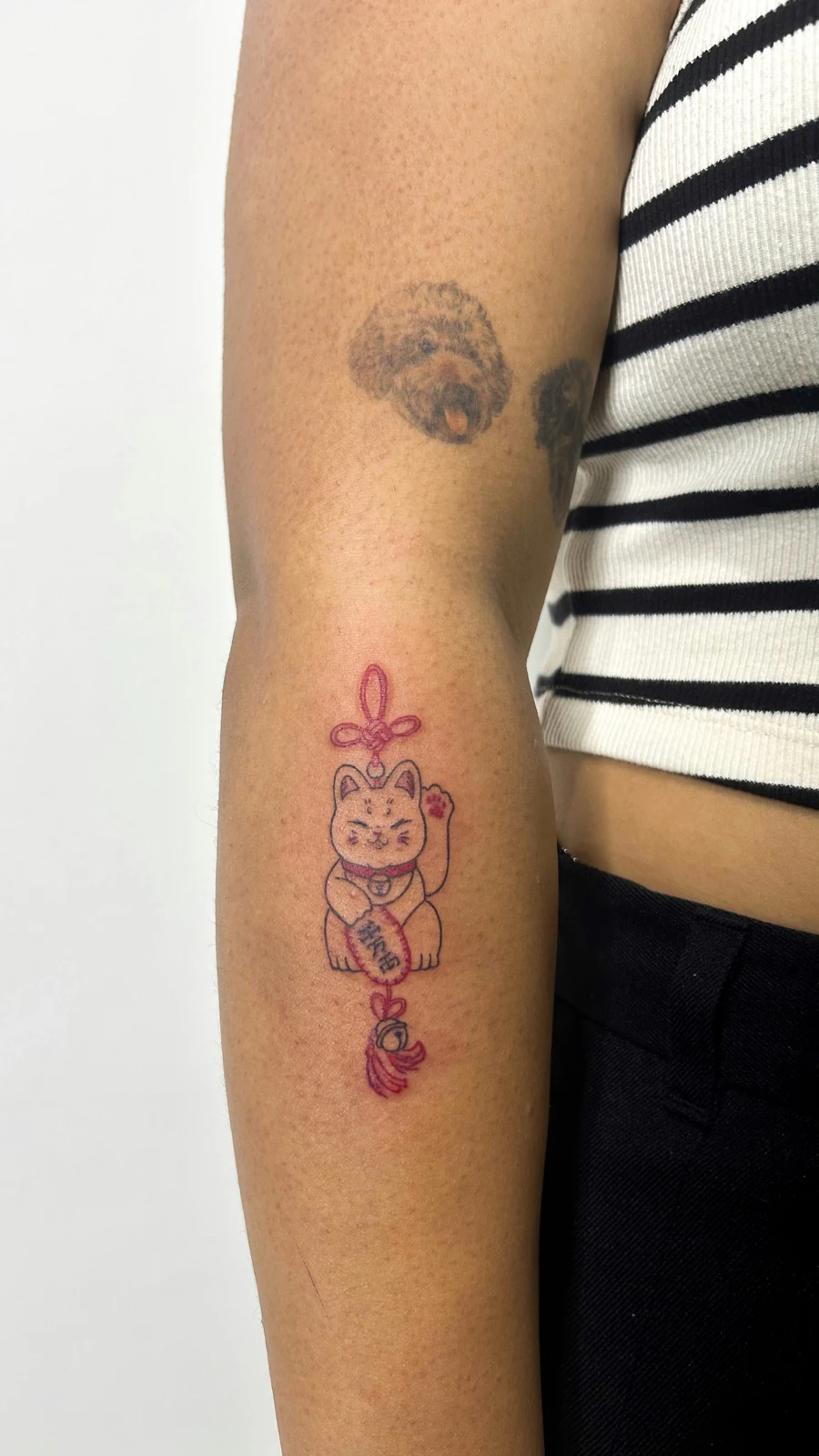 Tattoo figur merah muda di lengan · Meigu Tattoo